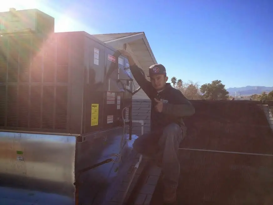 HVAC technician performing Boiler Repair on a rooftop unit in Gustine
